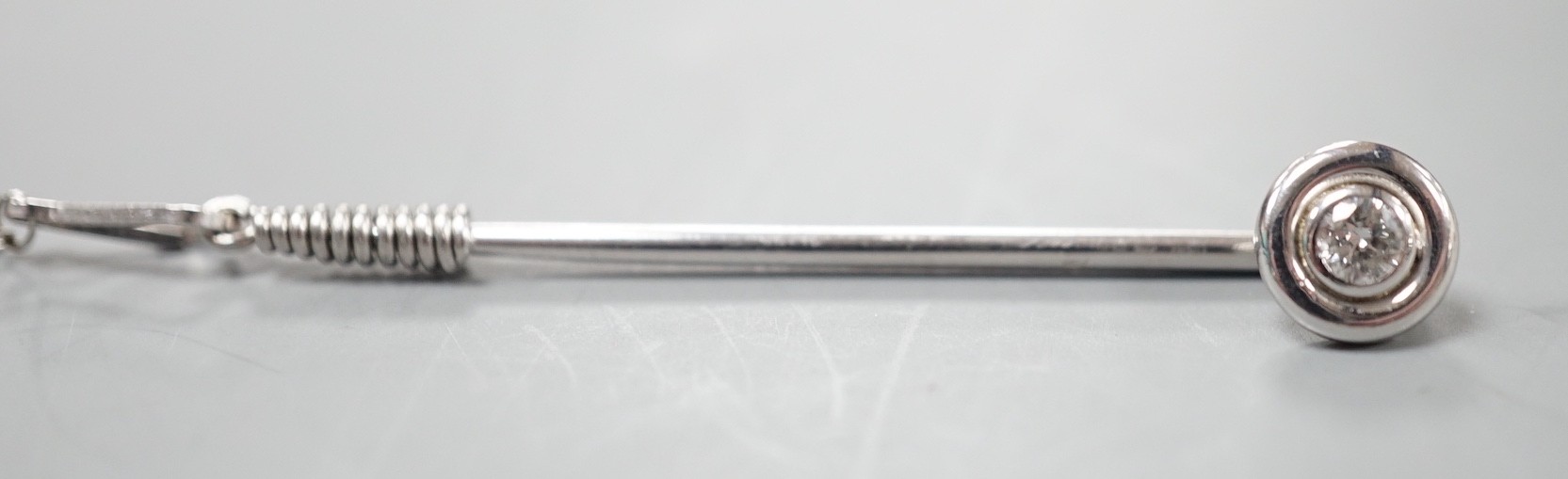 A white metal and collet set solitaire diamond tie pin, 43mm, with safety chain, gross weight 2.1 grams.